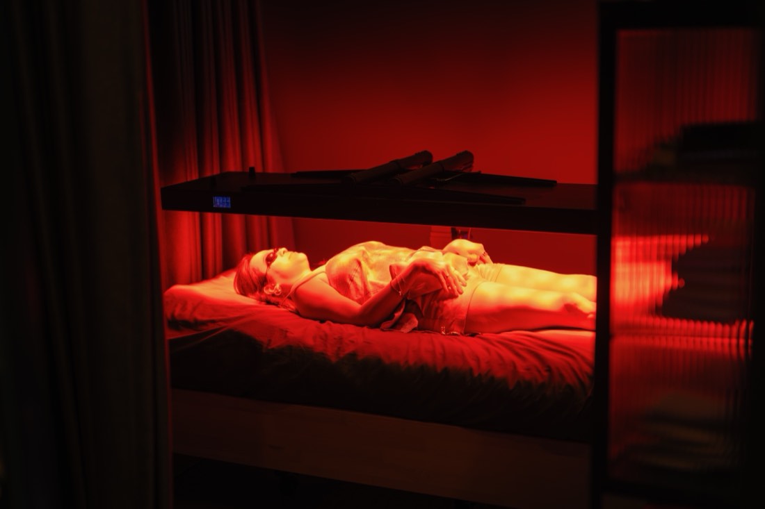 Guest resting on the full-spectrum red light bed